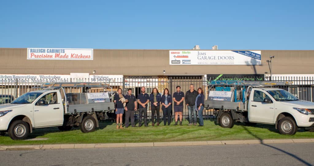 The Jims team standing outside with the company vehicles