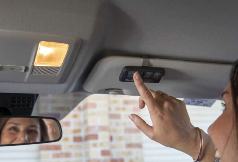 Person using garage door opener remote in car