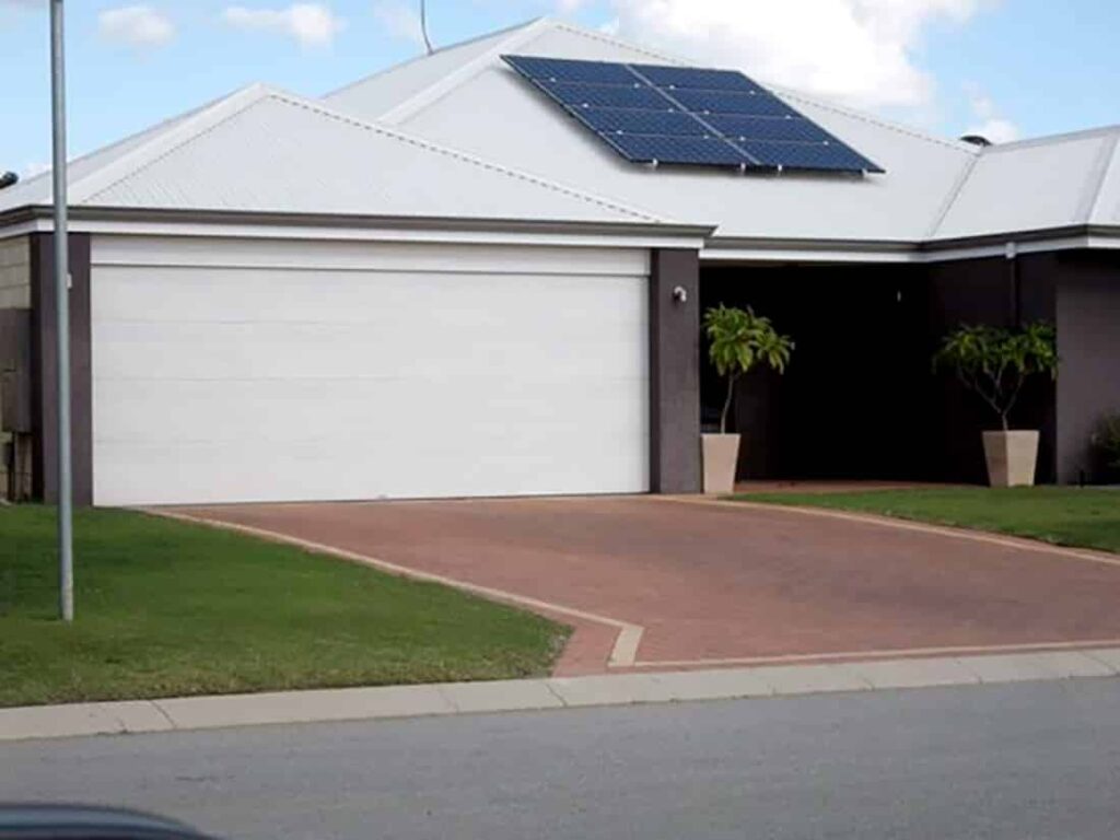 A house with solar panels and a white garage door